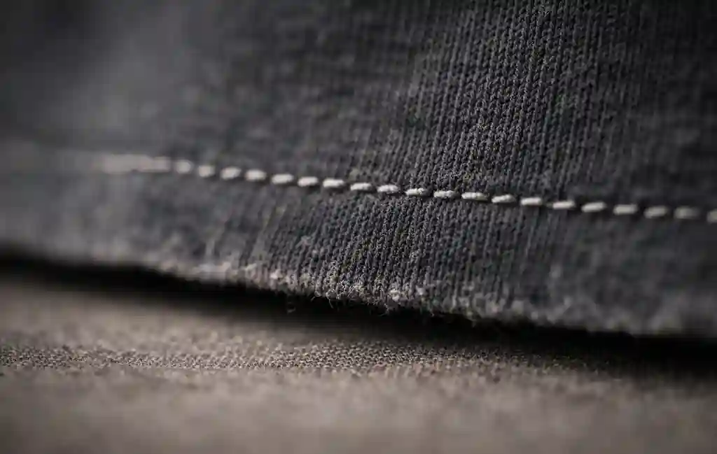 Close-up of single stitch hem construction on an authentic vintage band shirt.